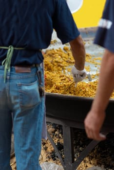 Serving an enormous paella  cooked on open fire