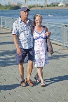 Aged loving couple walking and holding each other 