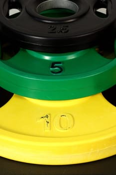 set of weight training colorful used weights, on top oeach other , vertical shot  
