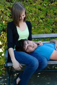 A young teen lying on his girlfriend's lap