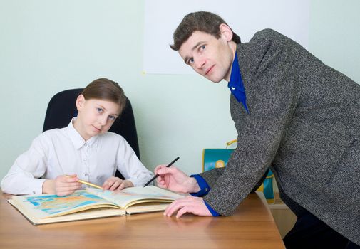 Tutor in a suit and schoolgirl with atlas