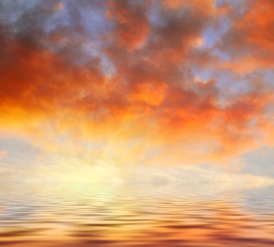 Orange clouds sunset reflecting in water.