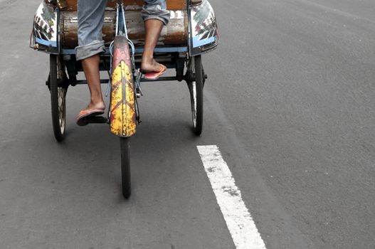 Taxi driver  in a  traditional indonesian taxi transport, becak