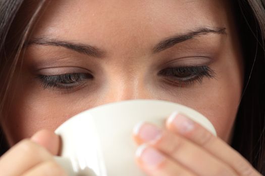 Young woman with beautiful face is having her tea/coffee