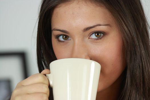 Young woman with beautiful face is having her tea/coffee