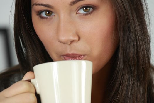 Young woman with beautiful face is having her tea/coffee