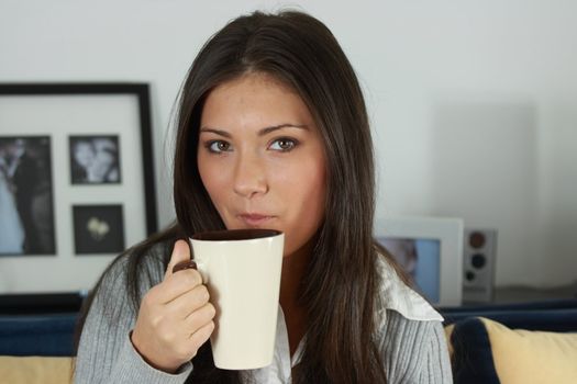 Young woman with beautiful face is having her tea/coffee