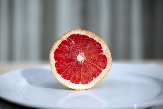 Half a grapefruit on white plate.