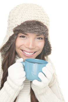 Winter woman drinking tea isolated. Cute smiling woman wearing winter hat and clothes drinking hot drink. Mixed Asian / Caucasian female model isolated on white background.