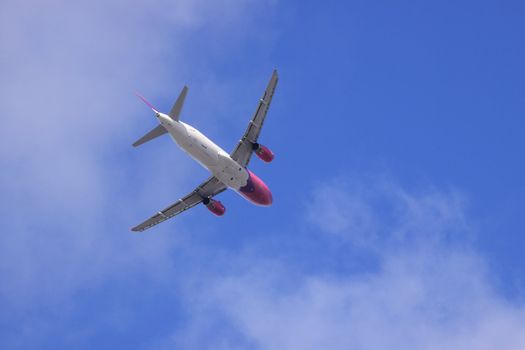 Jet airplane on almost clear blue sky witch some clouds