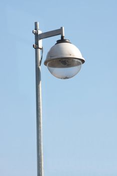 Surveillance security camera against clear blue sky