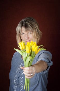 Pretty woman with a bunch of yellow tulips