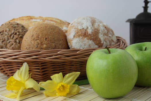 Variety of whole wheat bread in basket and greena apples