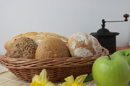 Variety of whole wheat bread in basket and greena apples