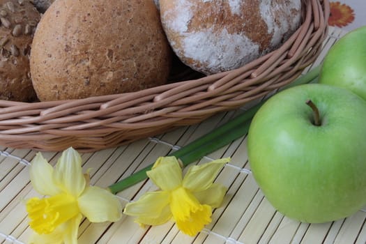 Variety of whole wheat bread in basket and greena apples