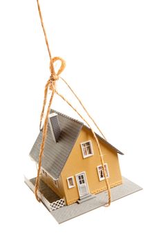 House Hanging by a String Isolated on a White Background.