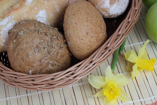 Basket of various fresh baked bread on wooden table