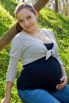Calm pregnant woman admiring spring outdoor nature