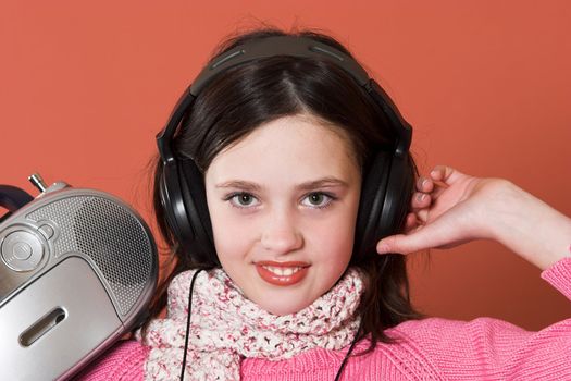 pretty girl listening music with headphones and holding portable CD radio