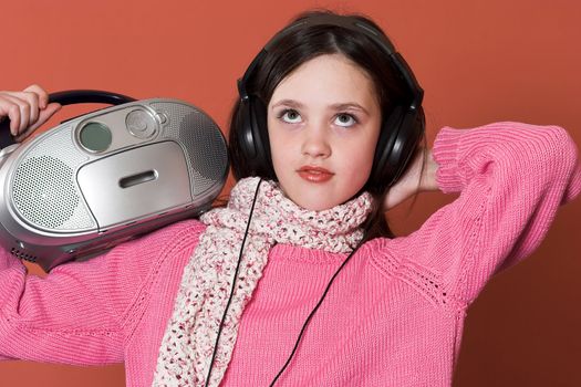 pretty girl listening music with headphones and holding portable CD radio