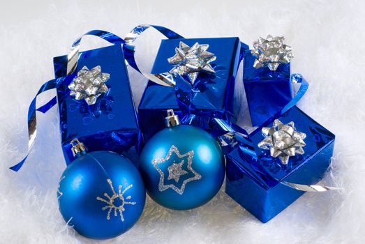 Blue boxes and Christmas blue balls are on the white fur