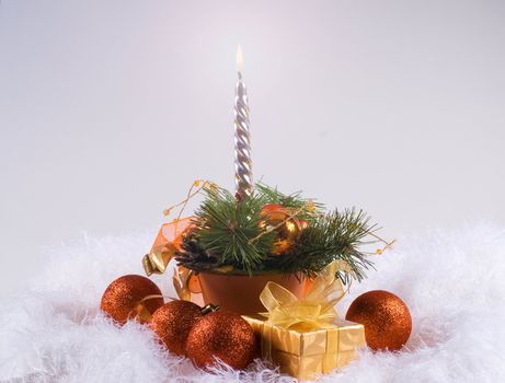 Christmas orange spheres and silver candles on the white fur