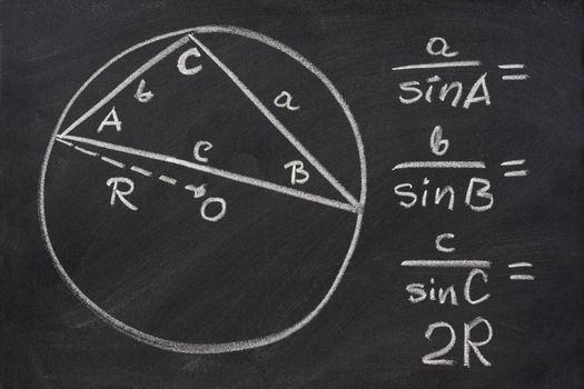 trigonometry indentity - law of sines sketched with white chalk on blackboard, eraser smudges