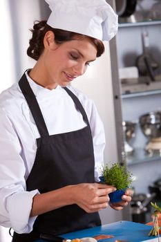 Female chef picking some garnish to use as decoration on her amuse
