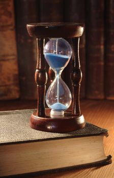 Still life with vintage hour glass and old books