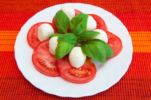 Tomatoes with mozzarella on the white plate