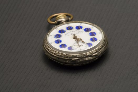 Antique silver clock on a black paper background