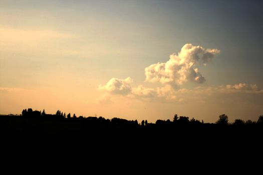 Silhouette of country under great clouds