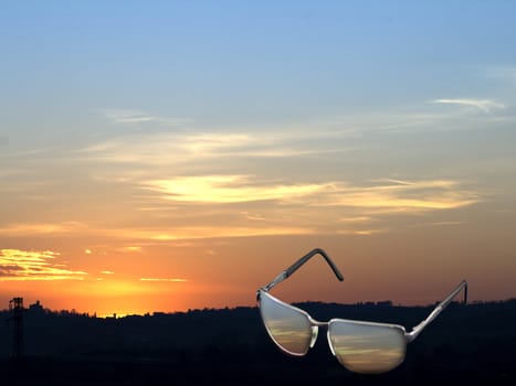 A pair of sunglasses on the silhouette of a town