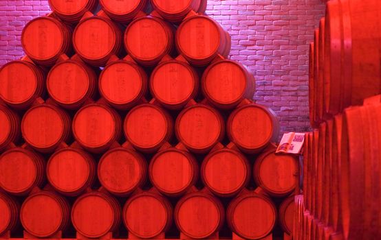 Pile of barrels of wine under red light