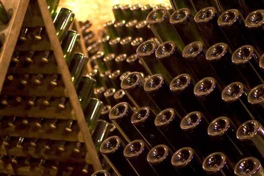 Closeup of bottles of wine aging in an old cellar