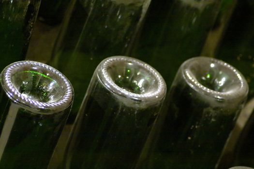 Closeup of bottles of wine aging in an old cellar