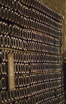 Closeup of bottles of wine aging in an old cellar