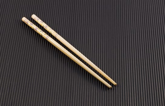 A pair of Chopsticks for Oriental food on black background
