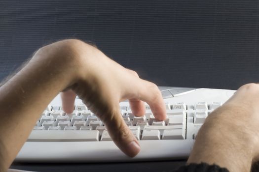 Male hands on white pc keyboard