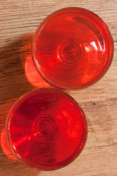 Two glasses with jelly stand on wooden, oak floor