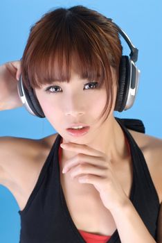 Glamor of Asian beauty with headphone over blue background.