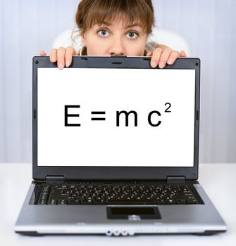 Young woman shows us a computer screen with formula