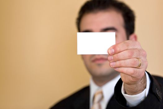 Close up of a man holding an empty business card up.  Plenty of copyspace for your logo or design.  Shallow depth of field.