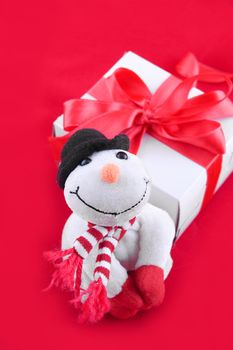 Snowman and giftbox on red background