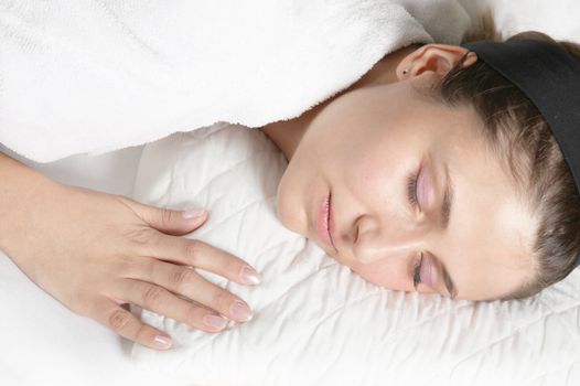 Sleeping and relaxing, beautiful woman with hair band is on a pillow
