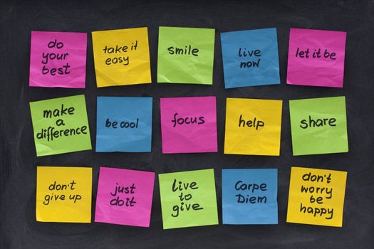 colorful sticky notes with uplifting and motiovational words of wisdom posted on blackboard with eraser smudges