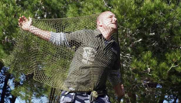 Mercenary male soldier caught and trapped in a net
