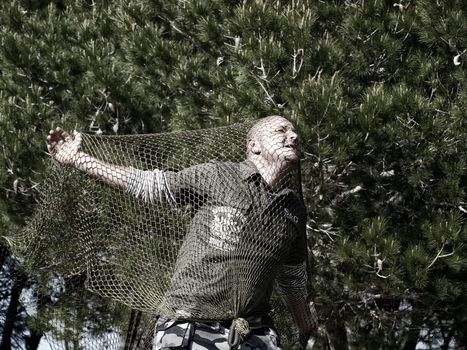 Mercenary male soldier caught and trapped in a net