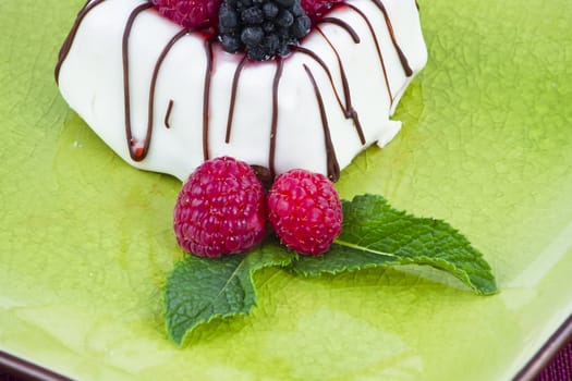 Black and White chocolate with blackberries on green plate