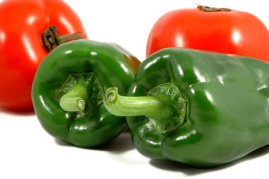Green papricas and red tomatoes over white